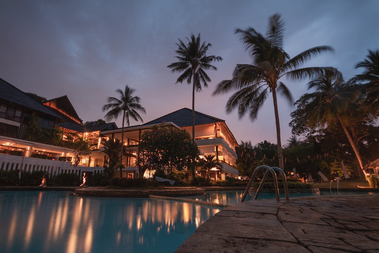Home Luxurious tropical resort with swimming pool and palms at dusk, perfect for a tranquil vacation.